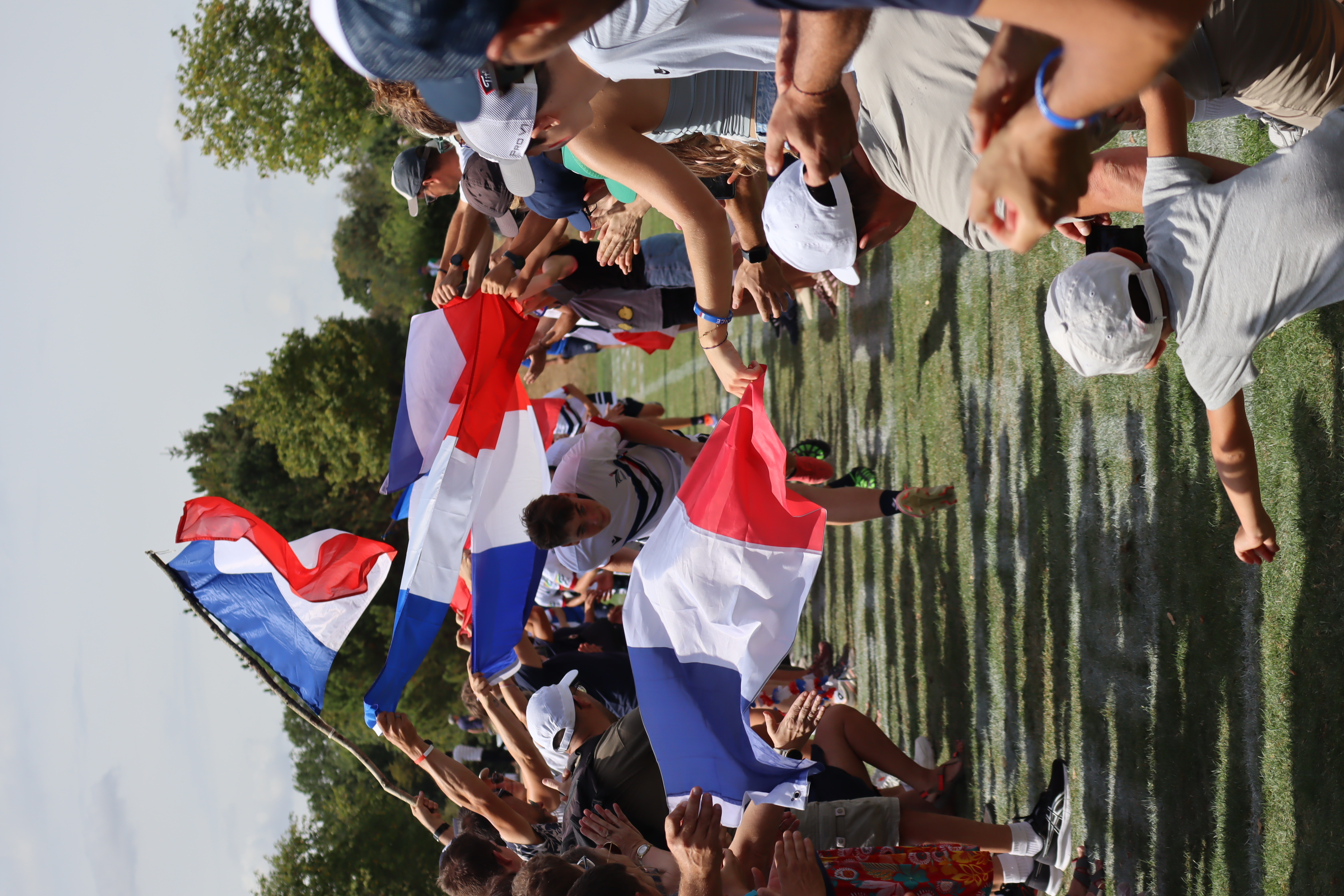 Un joueur de l’Équipe de France traverse une haie d’honneur sous les drapeaux français